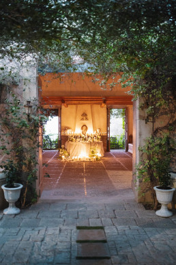 Illuminated passageway Sicilian villa at dusk with terracotta terrace and warm decorations