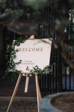 Elegant beige canvas welcome sign on wooden easel with 