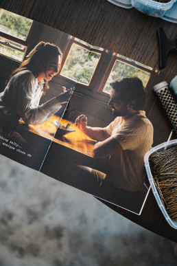 A printed photograph showing a couple at a table lit by a golden light