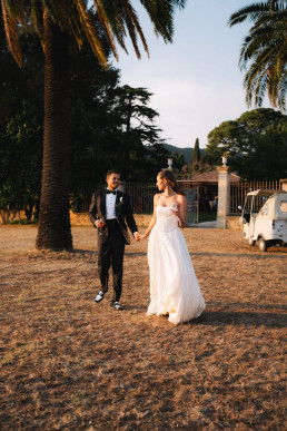 Wedding couple walking under the palm trees, a destination wedding in Bali captured by a destination wedding videographer