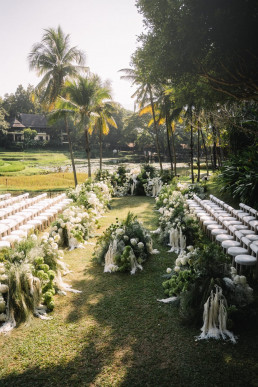 Outdoor garden wedding ceremony aisle with chairs and flowers in Bali, Indonesia, destination wedding photographer ceremony scene