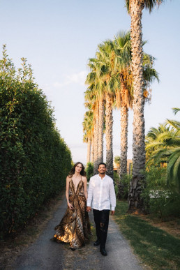 Couple walking between tall palm trees at sunset in Lombok, Indonesia, destination wedding photographer couple session