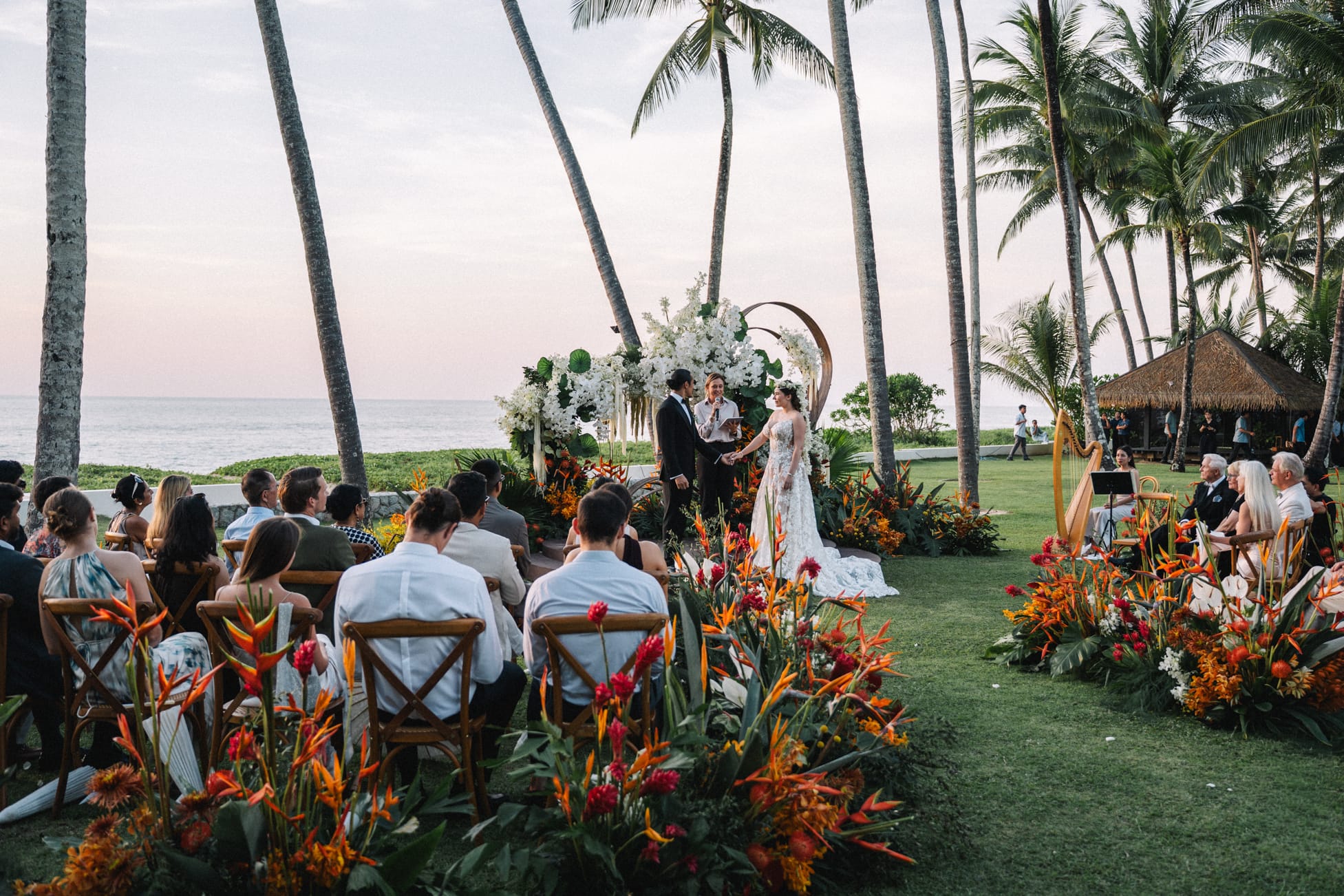 Outdoor wedding ceremony with floral aisle and guests seated facing the ocean in Phuket
