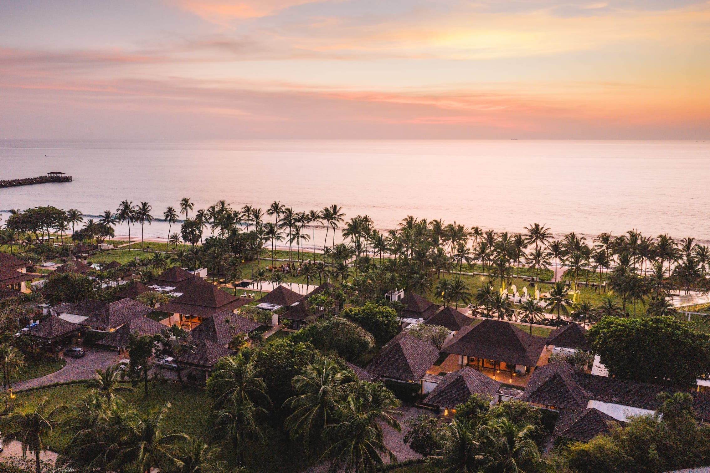 Beachfront luxury resort at sunset with palm trees and ocean view in Phuket Thailand
