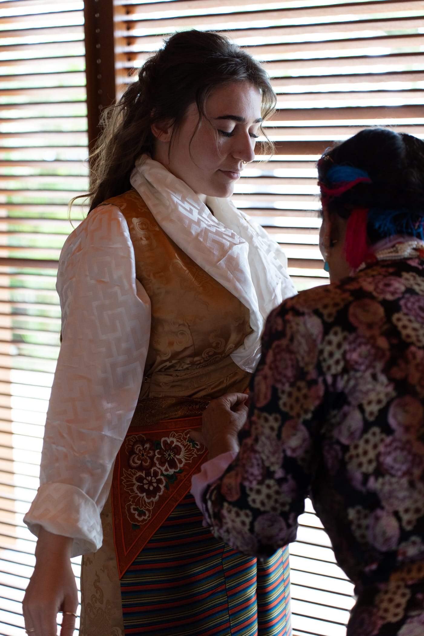 Bride getting dressed in traditional robe while preparing for the wedding