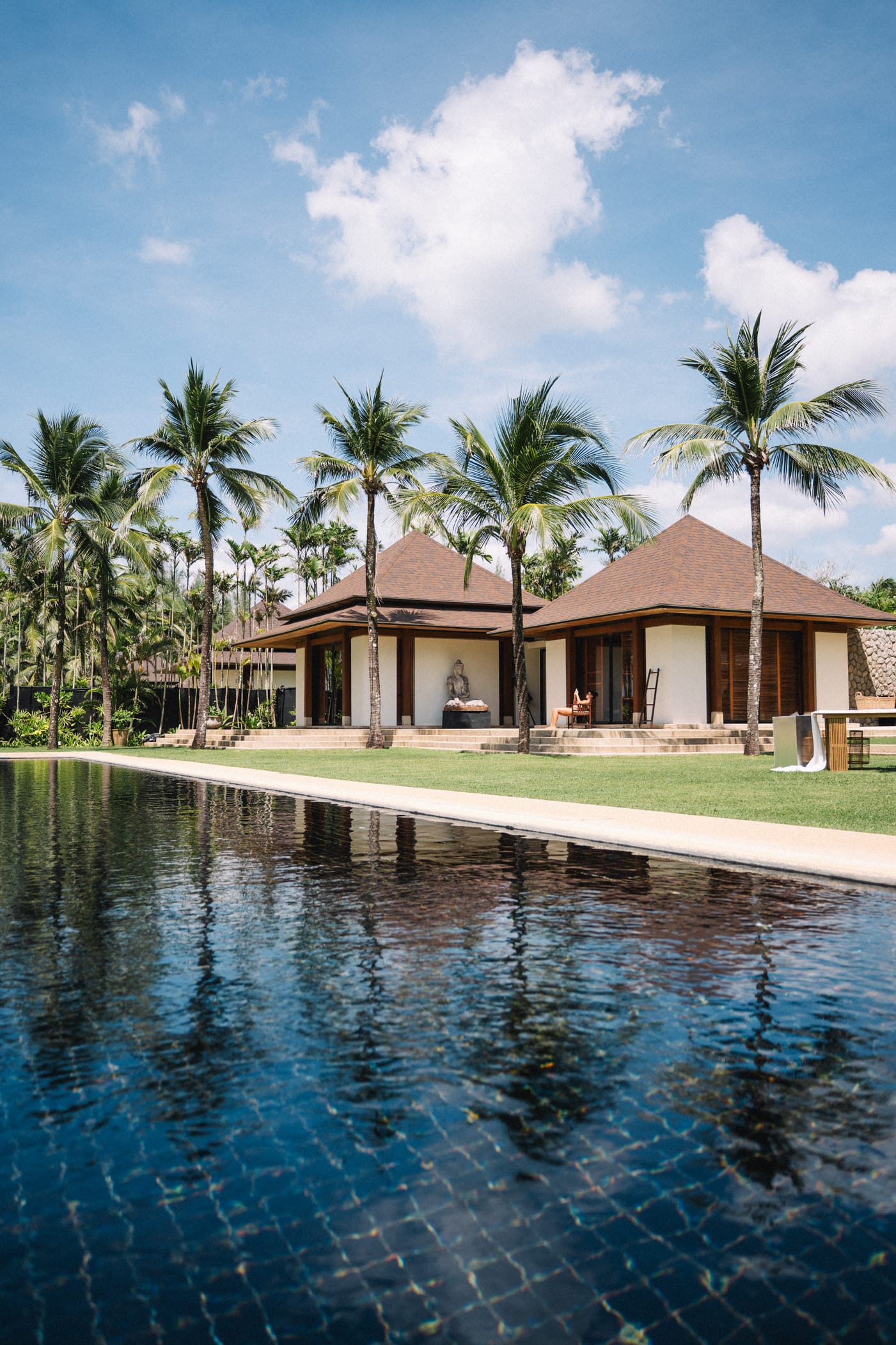 Luxury villa with private pool surrounded by palm trees at beachfront resort