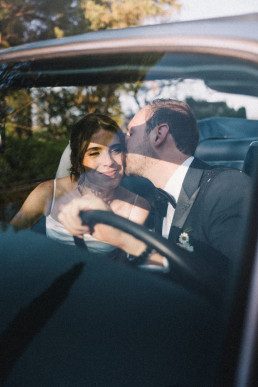 Couple kissing in a car in France, captured on Super 8 film with a cinematic vintage look. Soft light, intimate framing, and a nostalgic atmosphere, evoking a timeless and emotional moment.