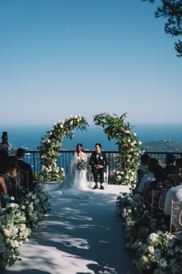 C&eacute;r&eacute;monie de mariage de luxe en ext&eacute;rieur face &agrave; la mer M&eacute;diterran&eacute;e avec arche florale et vue panoramique sur la French Riviera