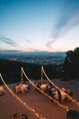 Vue a&eacute;rienne d&rsquo;un d&icirc;ner de mariage au coucher du soleil sur la C&ocirc;te d&rsquo;Azur avec guirlandes lumineuses et panorama sur la mer
