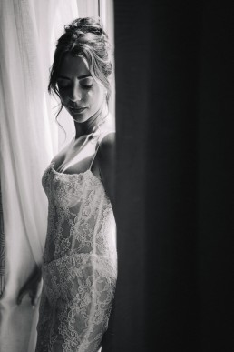 Mari&eacute;e en robe de dentelle pendant ses pr&eacute;paratifs dans une lumi&egrave;re douce