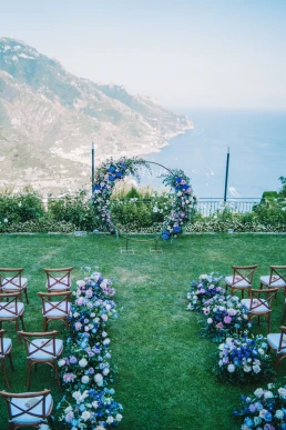 Outdoor wedding ceremony overlooking the Tuscan landscape with elegant floral design for a destination wedding.