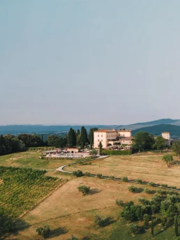 Aerial view of a luxury Tuscany wedding venue surrounded by vineyards and rolling countryside in Italy.