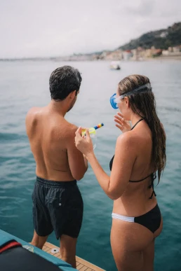 Couple swimming together during a day-after boat trip following their destination wedding