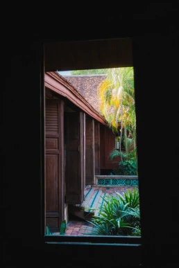 View from a dark wooden villa towards a tropical garden in Chiang Mai, Thailand