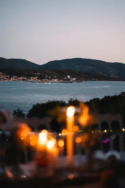 Candlelit tables overlooking the bay during an intimate wedding dinner in Corsica
