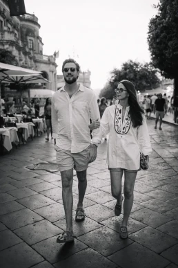 Black-and-white photograph of a couple walking through a seaside town on the French Riviera