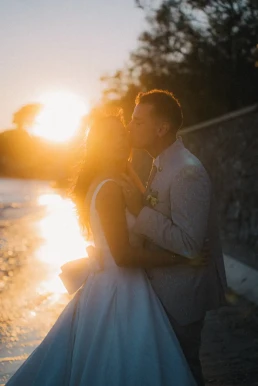 Bride and groom kissing by the sea at sunset during their French Riviera elopement