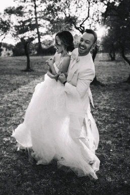 Black-and-white portrait of the groom lifting the bride during their elopement in Italy