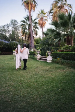 Bride and groom walking through a palm-lined garden during their elopement in Koh Samui, Thailand