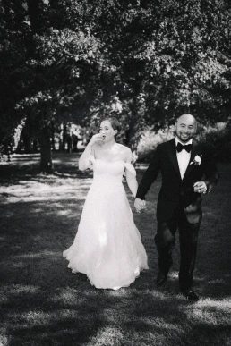 Black-and-white portrait of the bride and groom walking through a garden at Lake Como