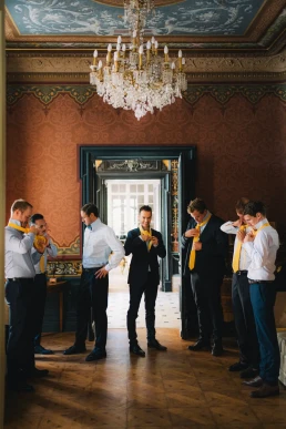 Groomsmen sharing a celebratory drink inside the wedding venue at Château Valmousse