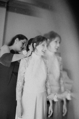 Black-and-white photograph of bridesmaids helping the bride prepare at Château Valmousse