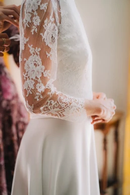 Close-up of the lace sleeves and waist of the bride's wedding dress at Château Valmousse
