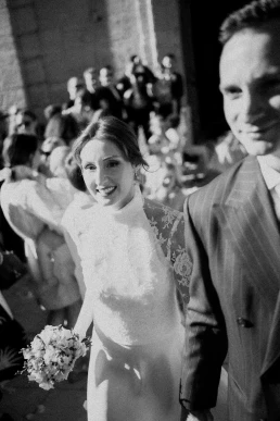 Black-and-white photograph of the bride leaving the ceremony with her father at Château Valmousse