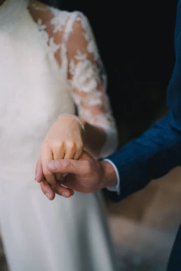 Bride and groom holding hands, showing their wedding rings at Château Valmousse