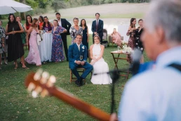 Bride and groom listening to live music with their guests at Château Valmousse