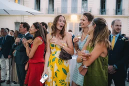 Wedding guests sharing a lively moment during cocktail hour at Château Valmousse