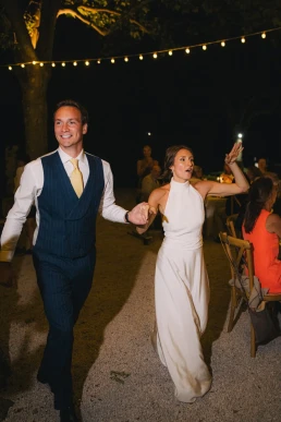 Bride and groom walking hand in hand into their evening reception at Château Valmousse