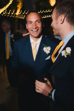 Two male wedding guests talking during the reception at Château Valmousse