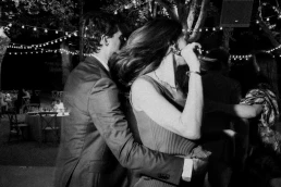 Black-and-white photograph of a wedding guest embracing a woman on the dance floor at Château Valmousse