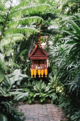 Traditional spirit house surrounded by tropical plants in Phuket, Thailand