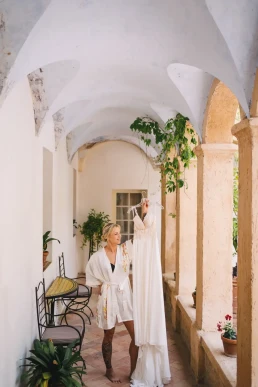 Bride walking through the arched courtyard of her wedding venue in Portugal