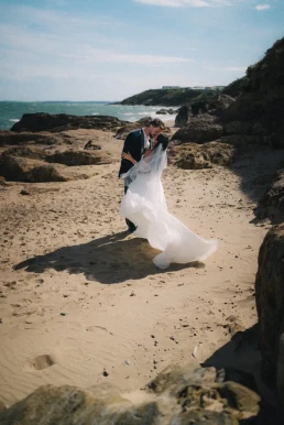 Bride and groom walking across a rocky beach during their elopement in Portugal