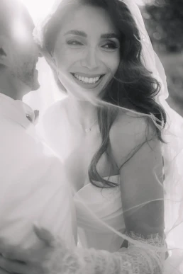 Black-and-white portrait of a smiling bride beneath her veil during an elopement in Portugal