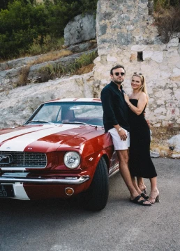 Couple posing beside a red vintage car during their elopement in Provence