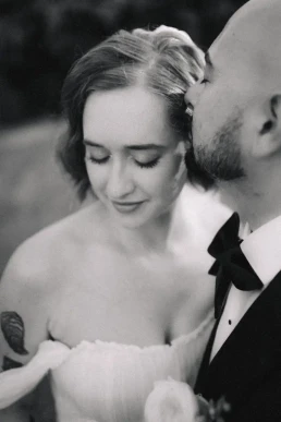 Black-and-white close-up of the groom kissing the bride's forehead in Scotland