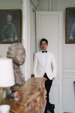 Groom in a tuxedo standing inside a historic wedding venue in Scotland