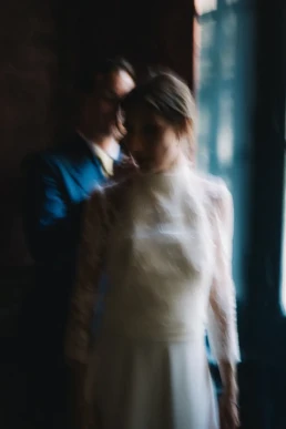 Soft-focus portrait of the bride and groom beside a window in Switzerland