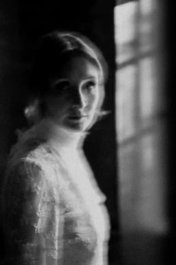 Black-and-white bridal portrait beside a window during an elopement in Switzerland