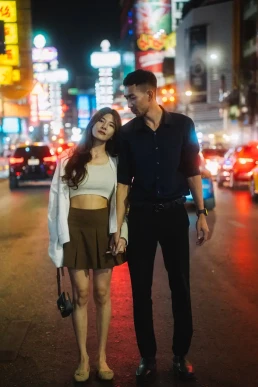Couple exploring a lively city street at night during their elopement in Thailand